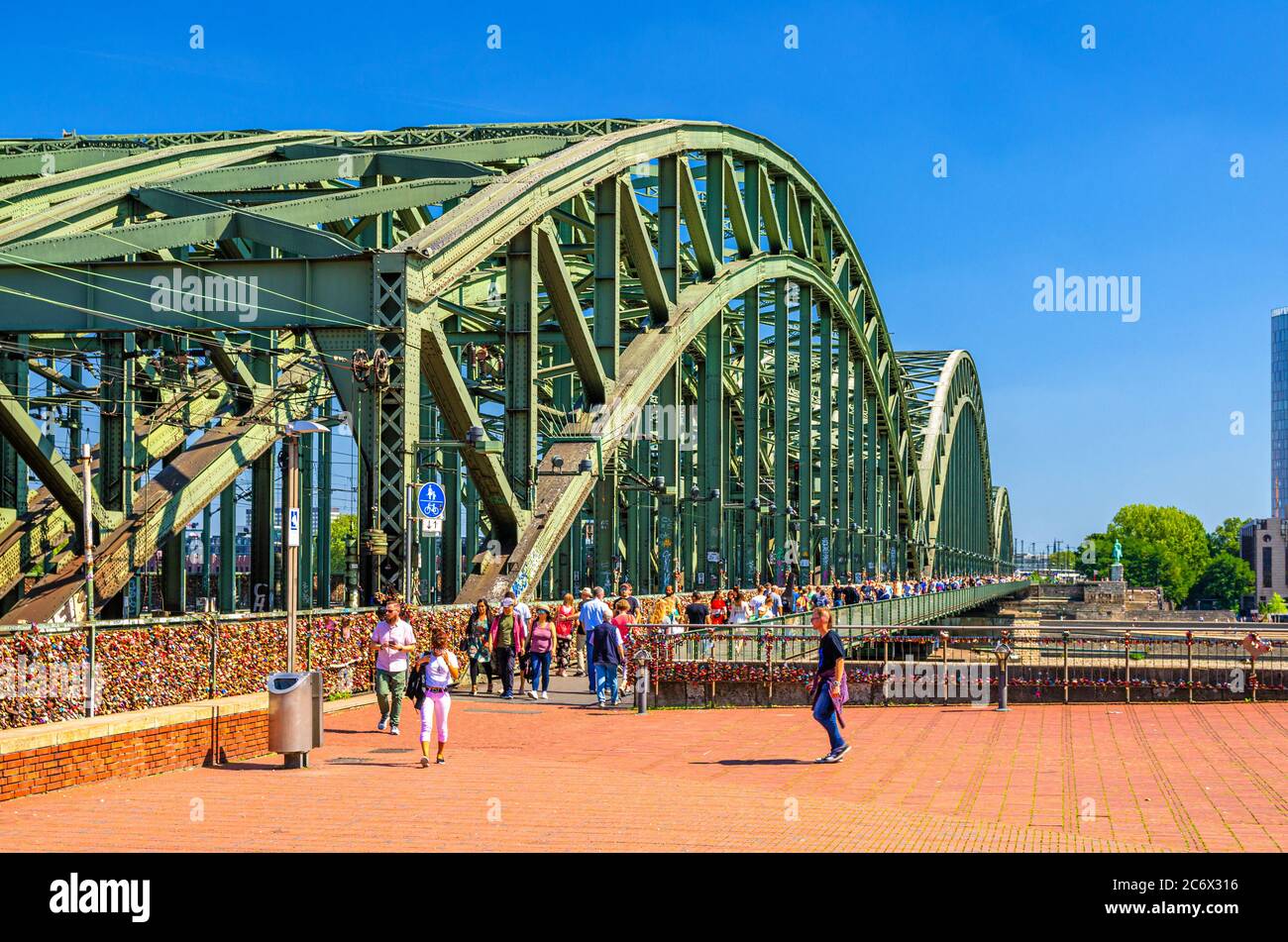Köln, 23. August 2019: Touristen zu Fuß über die Hohenzollernbrücke oder die Hohenzollernbrücke über den Rhein, Fußgänger- und Eisenbahnstahlbrücke, blauer Himmel im sonnigen Tageshintergrund Stockfoto