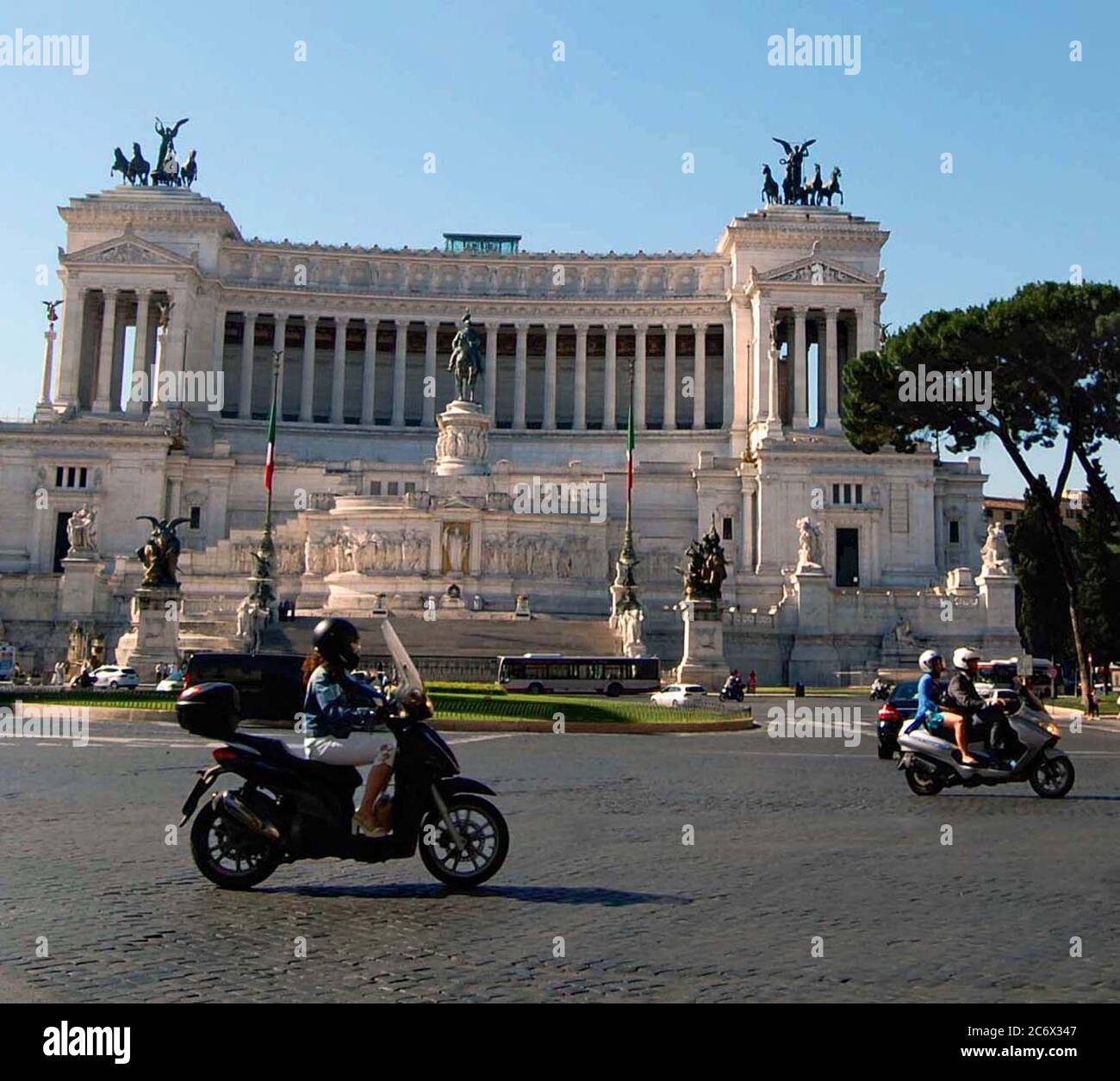 Motorräder passieren die Altare della Patria, "Altar des Vaterlandes", das Nationaldenkmal für König Viktor Emanuel II in Rom, Italien Stockfoto