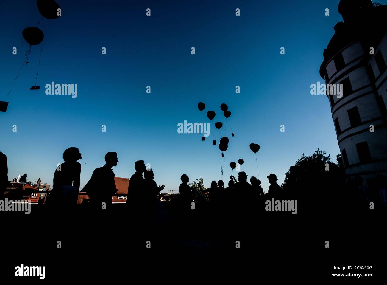 Silhouetten von Paar und ihren Freunden auf der Hochzeitsfeier mit Ballons übergossen Stockfoto