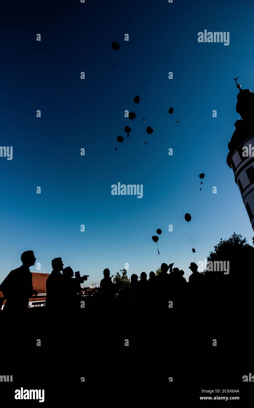 Silhouetten von Paar und ihren Freunden auf der Hochzeitsfeier mit Ballons übergossen Stockfoto