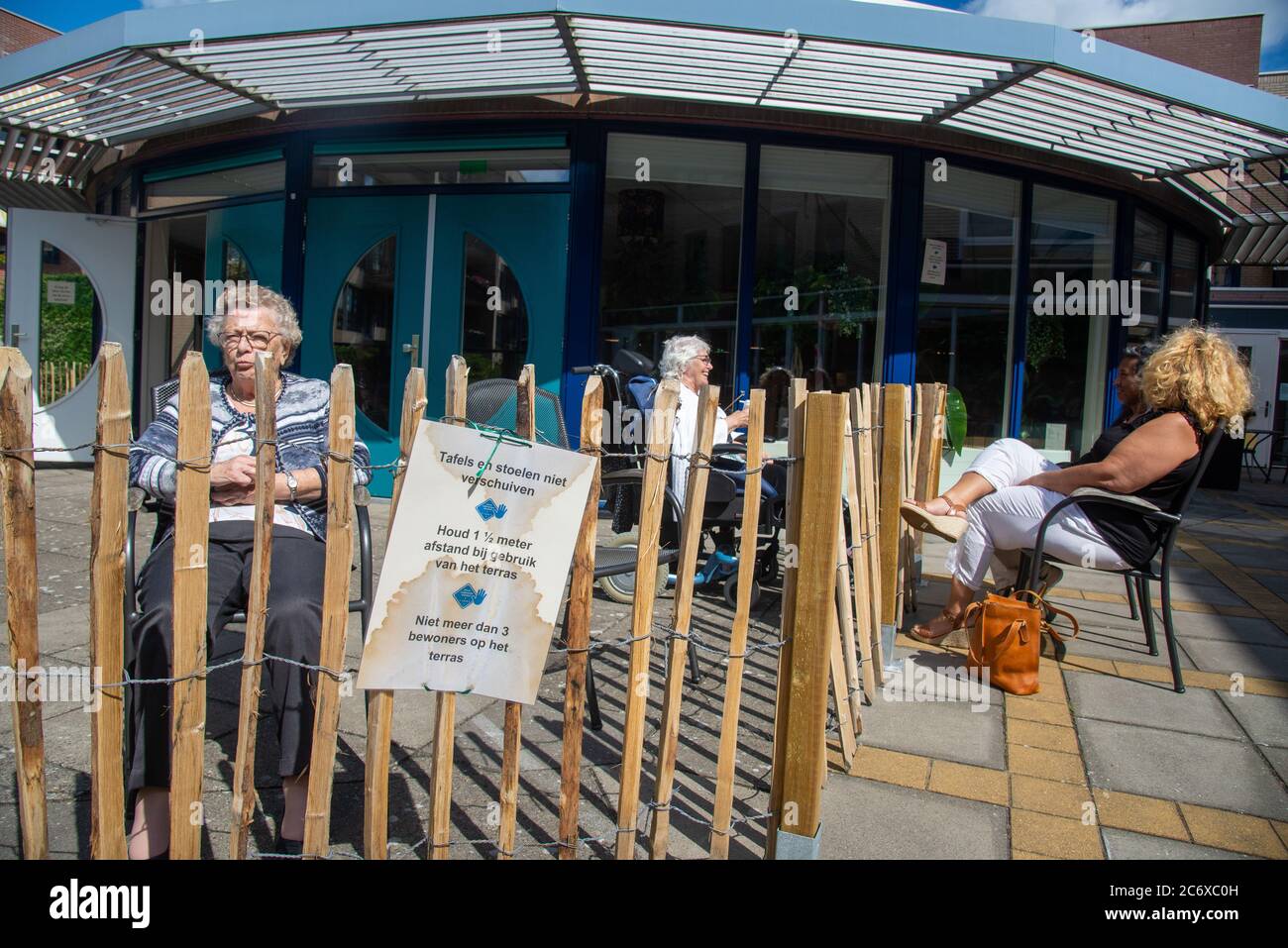 Alte Leute hinter Zaun während der Besuchszeiten in Covid-19 Zeit im Haus für Rentner in Holland Stockfoto