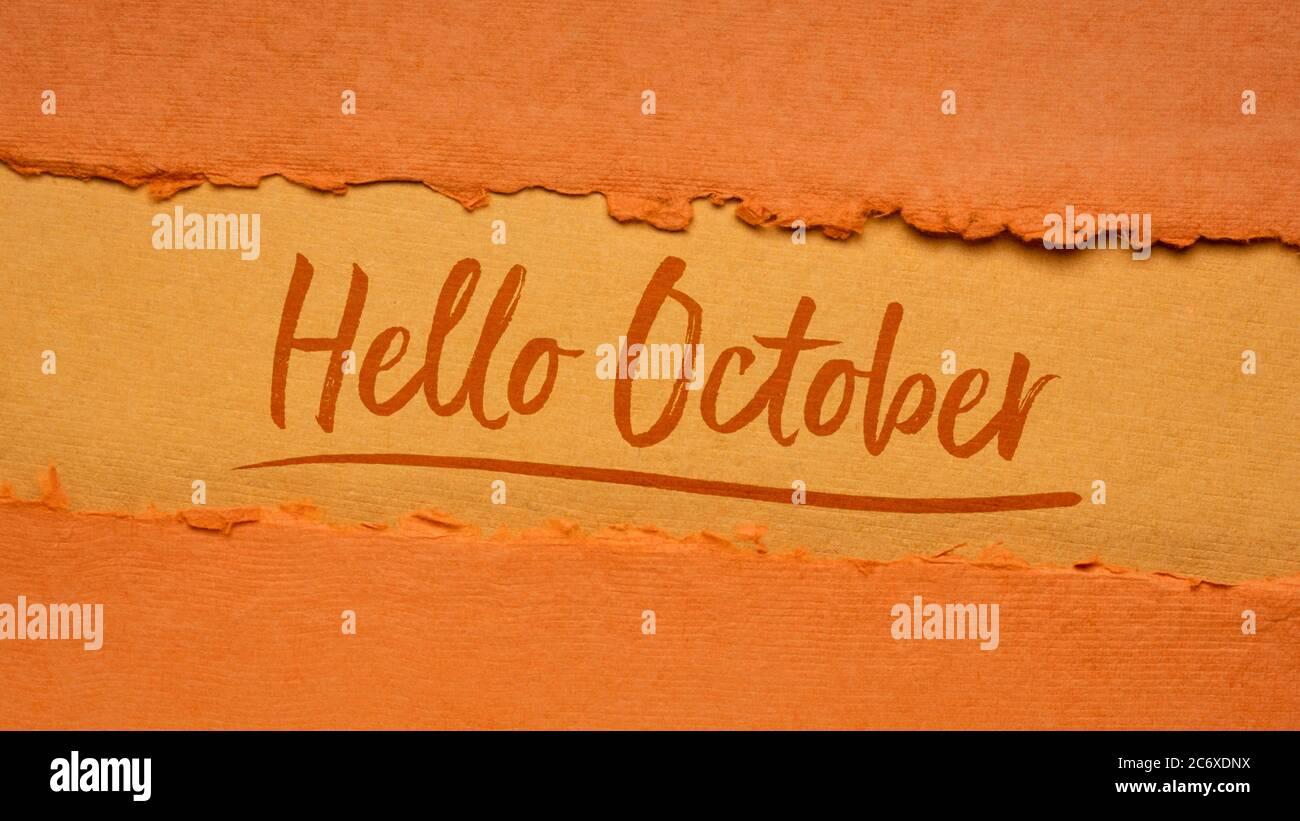Hallo Oktober Begrüßungsnote - Handschrift auf einem handgefertigten Stoffpapier in Kürbisorange Tönen, Kalenderkonzept Stockfoto