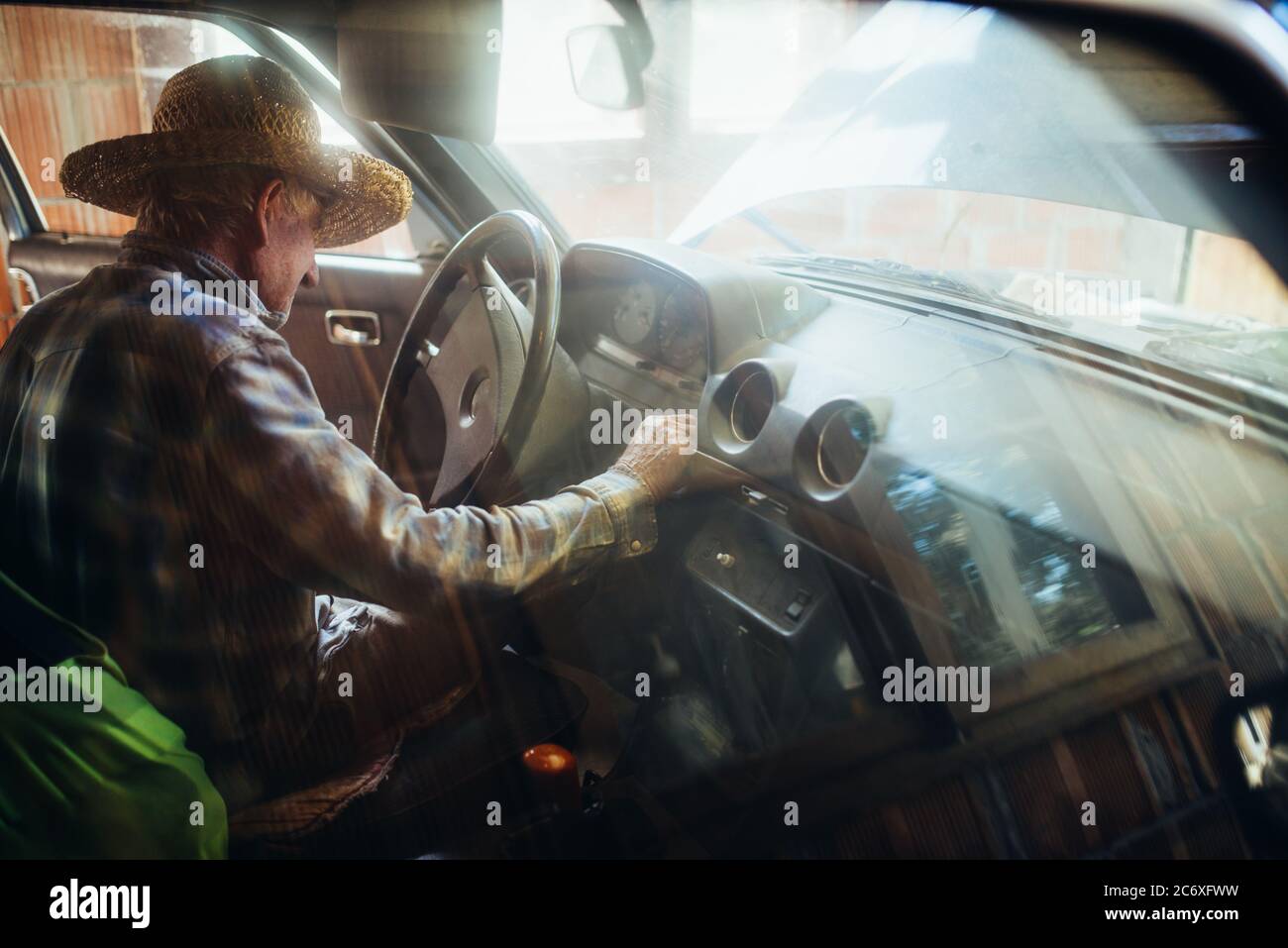 Alter Mann, der den Zündstartknopf drückt Stockfoto