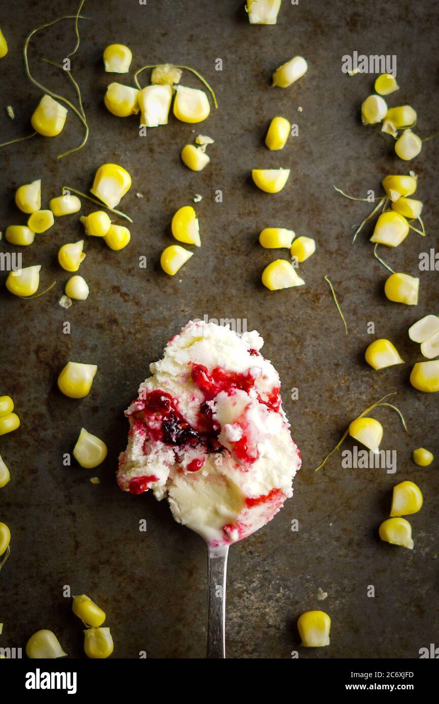 Süßes Maiseis mit Brombeersauce Stockfoto