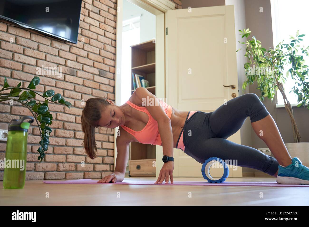 Fit sportliche Frau Rollen auf Schaum Massage Roller tun Übung zu Hause. Stockfoto