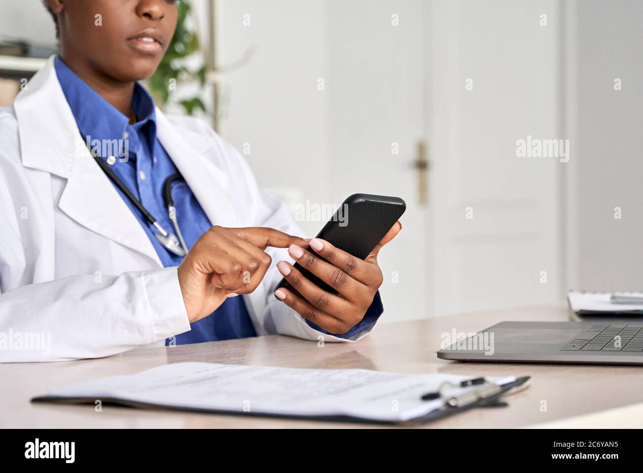 Afrikanische Ärztin in den Händen mit Smartphone, Nahaufnahme. Stockfoto