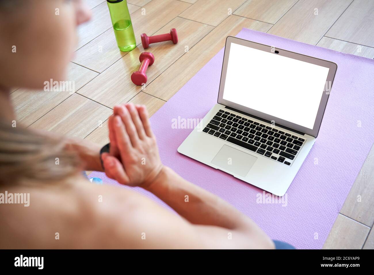 Über der Schulter Ansicht der Frau meditieren Online-Yoga auf Laptop-Modell Bildschirm. Stockfoto