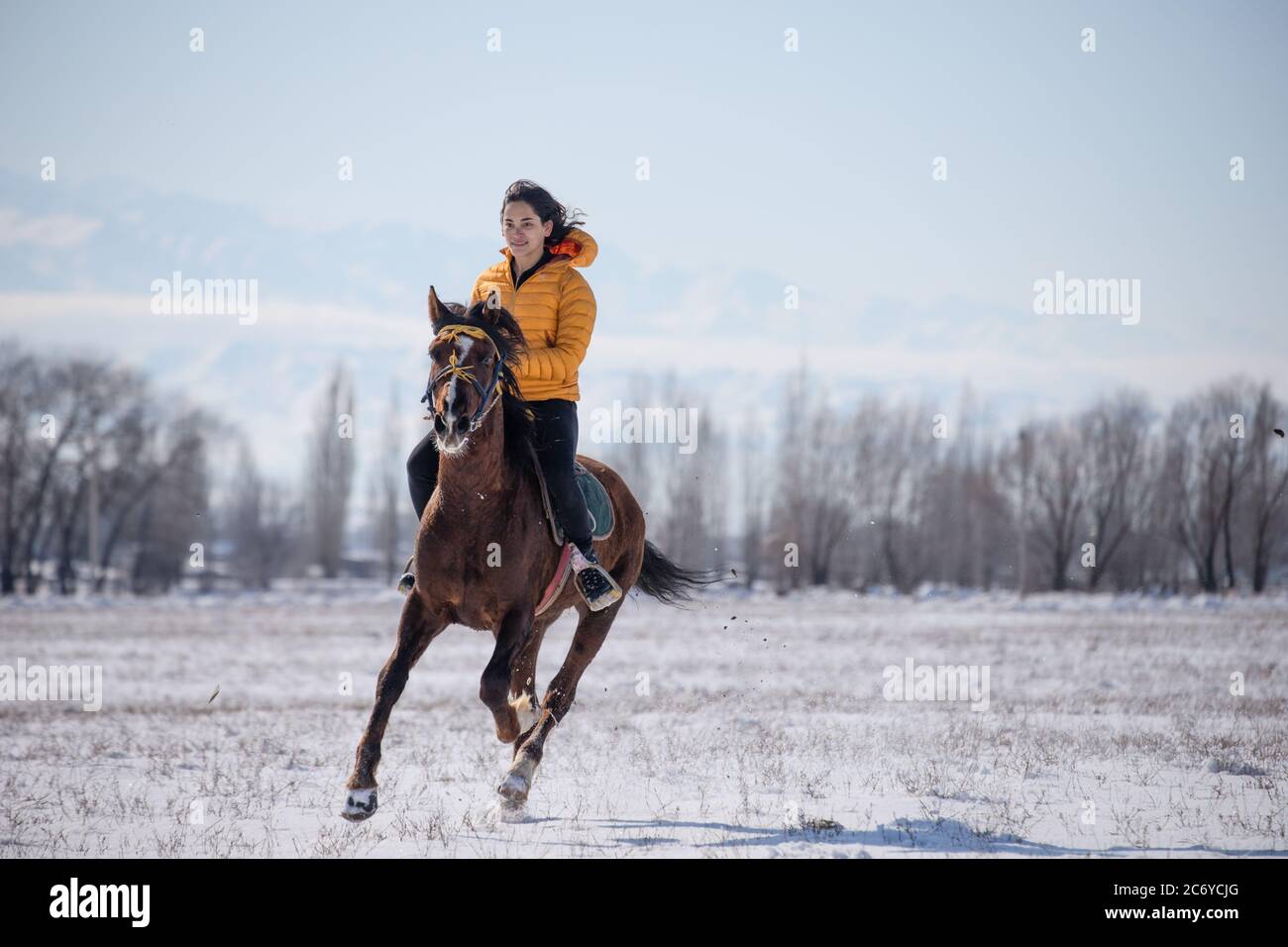Eine ausländische Touristenin reitet ein einheimisches Pferd während eines Dorffiels Kok Boru im Gebiet Chuy in Kirgisistan in der Nähe der Hauptstadt Bischkek. Stockfoto