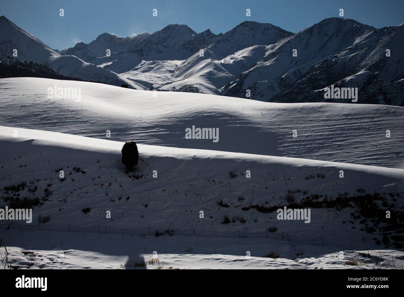 Verschneite Berghänge direkt hinter den Pisten des Chunkurchak Ski Base im Gebiet Chuy in Kirgisistan bei Bischkek. Stockfoto