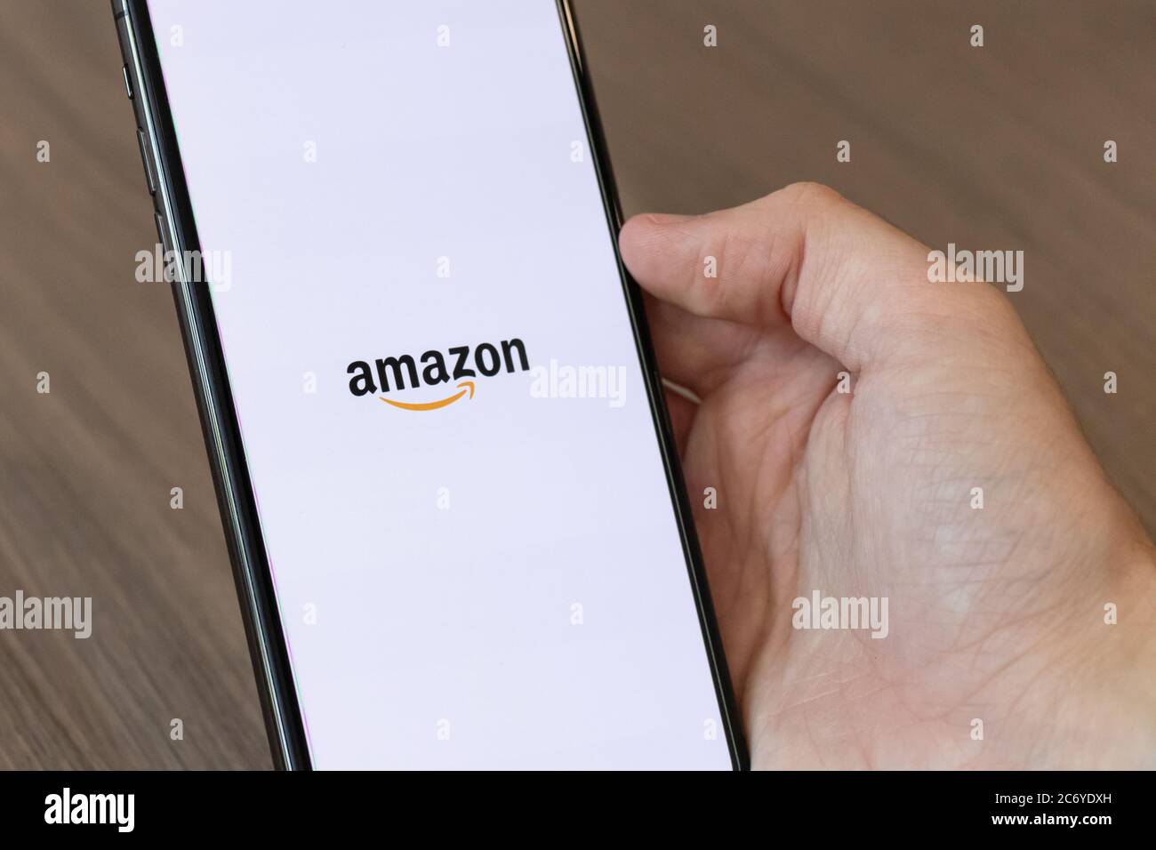 Person, die ein Mobiltelefon mit dem Amazon, Inc.-Logo auf dem Bildschirm verwendet. Stockfoto