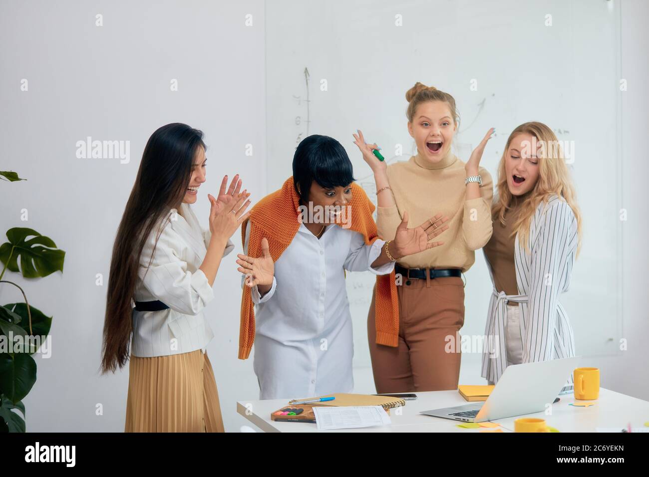 Überraschte Frauen in Freizeitkleidung im Büro zusammen, in Schock mit geöffnetem Mund. Feiern Sie ihren Sieg in Business-Projekt, gute Arbeit der vielfältigen weiblichen Stockfoto