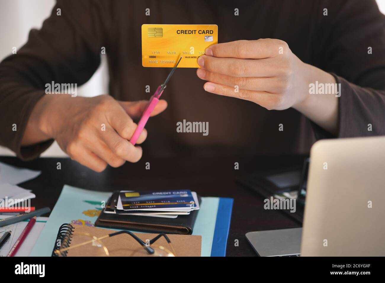 Mann Hände verwenden Schere Kreditkarten zu schneiden, Konzept für die Auszahlung Schulden aussteigen, aufhören mit Kreditkarten am Schreibtisch, konzentrieren sich auf Kreditkarte flach DOF Stockfoto