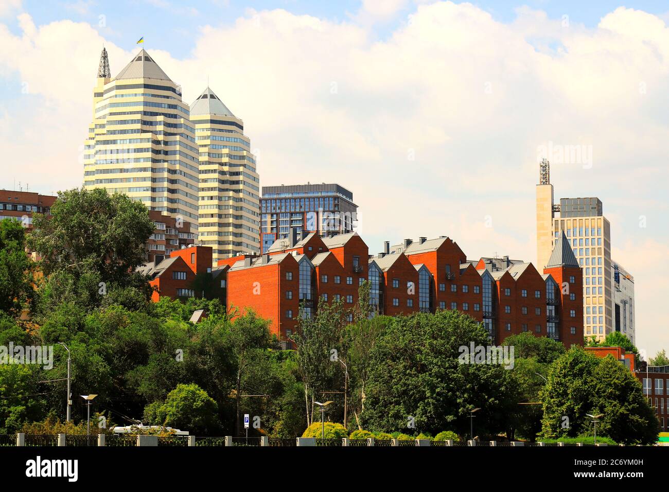 Schöne Frühlings- und Sommeransicht der Großstadt, der roten Gebäude, der weißen Wolkenkratzer und des Parks in der Dnipro-Stadt. Dnepropetrovsk, Ukraine Stockfoto