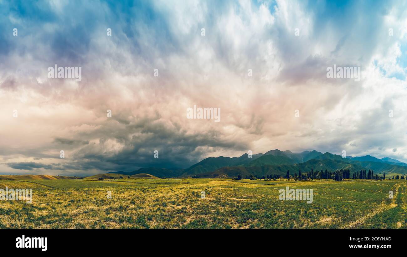 Panorama eines Bergtals im Sommer, wolkigen Himmel. Märchenhafter Sonnenuntergang über den Berggipfeln, herrliche Natur, Sommer in den Bergen. Reisen. Be Stockfoto