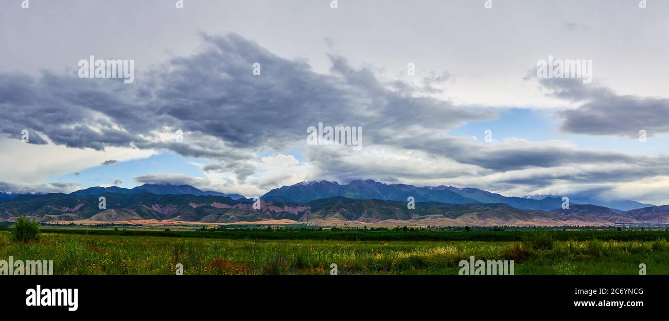 Panorama eines Bergtals im Sommer, wolkigen Himmel. Märchenhafter Sonnenuntergang über den Berggipfeln, herrliche Natur, Sommer in den Bergen. Reisen. Be Stockfoto