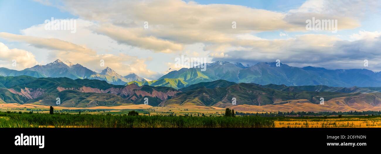 Panorama eines Bergtals im Sommer, wolkigen Himmel. Märchenhafter Sonnenuntergang über den Berggipfeln, herrliche Natur, Sommer in den Bergen. Reisen. Be Stockfoto