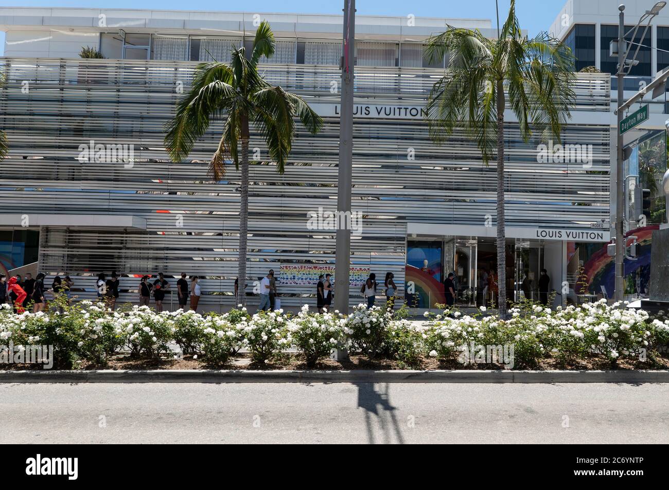 Beverly Hills, CA/USA - 12. Juli 2020: Eine lange Reihe von sozial distanzierenden Kunden in Gesichtsmasken warten vor dem Louis Vuitton Store Rodeo Drive Stockfoto