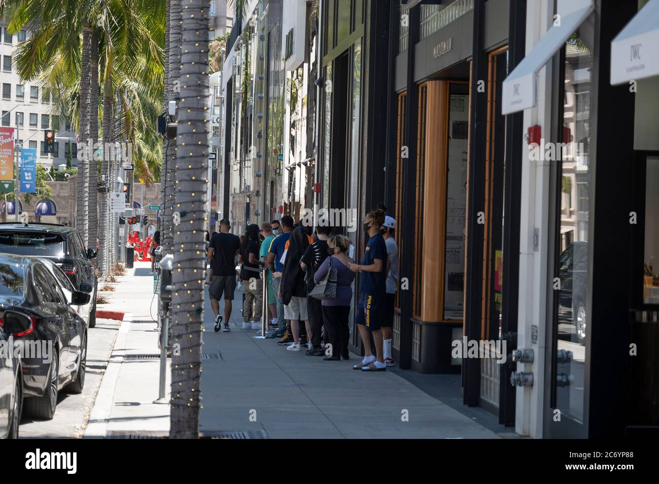 Beverly Hills, CA/USA - 12. Juli 2020: Eine Reihe von sozial distanzierenden Kunden in Gesichtsmasken warten vor den Geschäften am Rodeo Drive Stockfoto