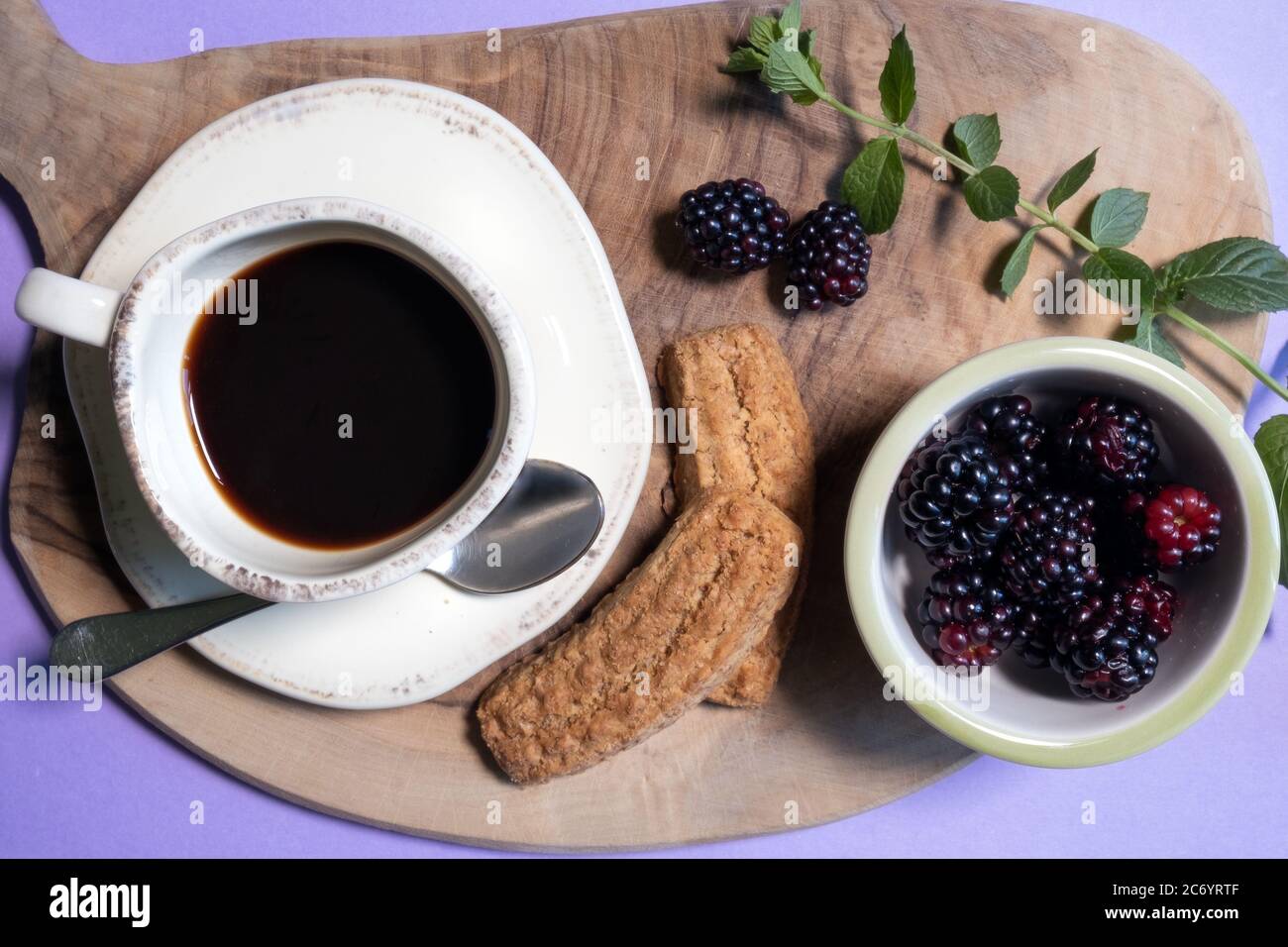 Elegante flache Lay eines italienischen gesunden Frühstück: tasse Kaffee, Kekse, Brombeeren und einige dekorative Minzblätter Stockfoto