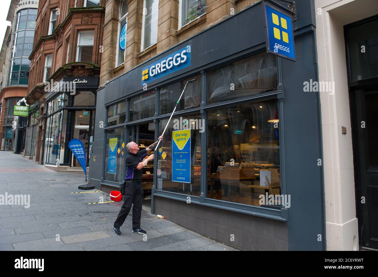 Glasgow, Schottland, Großbritannien. Juli 2020. Im Bild: Ein Fensterputzer wäscht die Schaufenster von Gregs schnell, so dass sie am frühen Morgen funkeln. Szenen aus der Buchanan Street im Stadtzentrum von Glasgow. Quelle: Colin Fisher/Alamy Live News Stockfoto