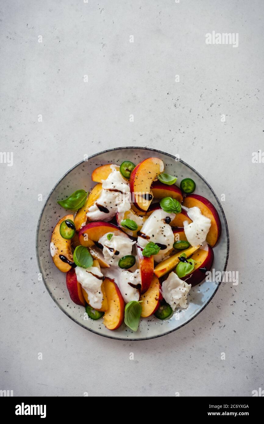 Frischer Salat mit Pfirsichen und Buratta-Käse Stockfoto