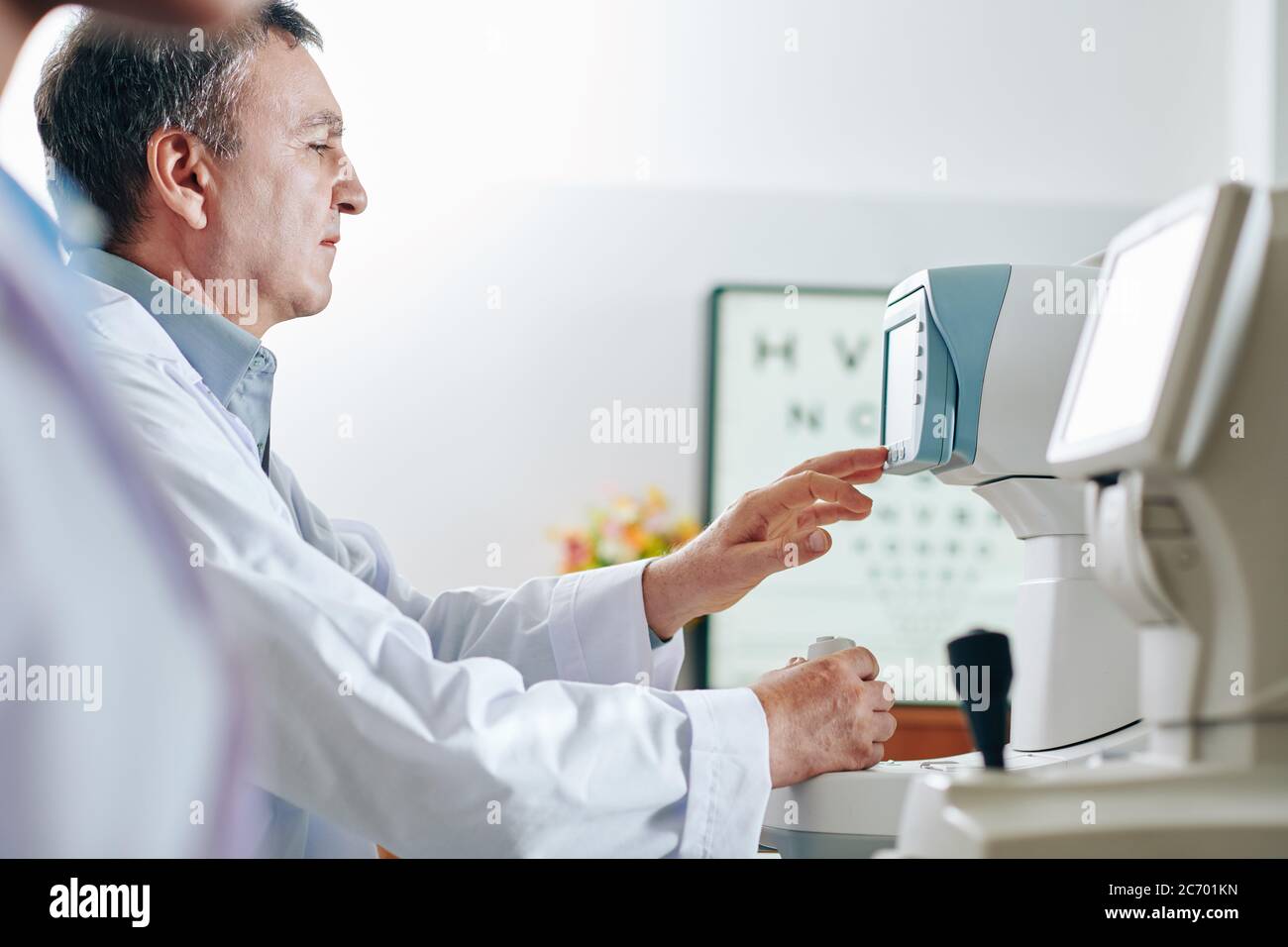 Konzentrierter Low-Vision-Spezialist, der in seinem Büro an modernen Geräten arbeitet Stockfoto