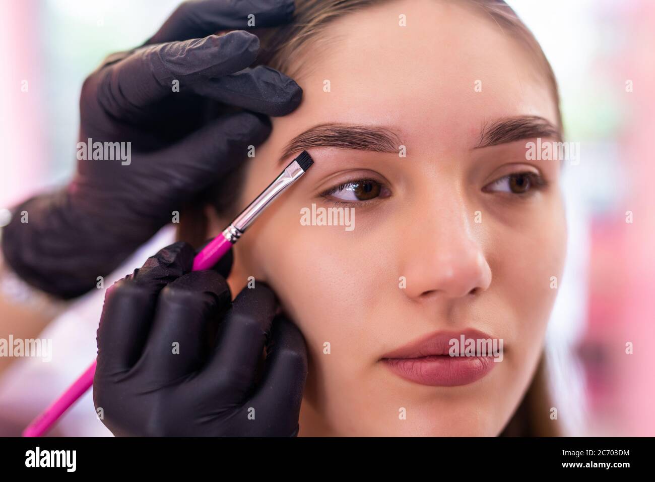 Schöne junge Frau bekommt Augenbraue Korrektur Verfahren. Junge Frau malt ihre Augenbrauen in Beauty Salon. Stockfoto