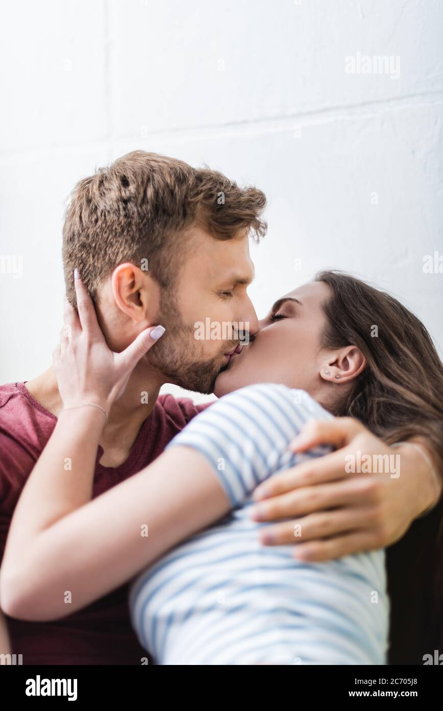 Glücklich junges Paar umarmt und küsst zu Hause Stockfoto