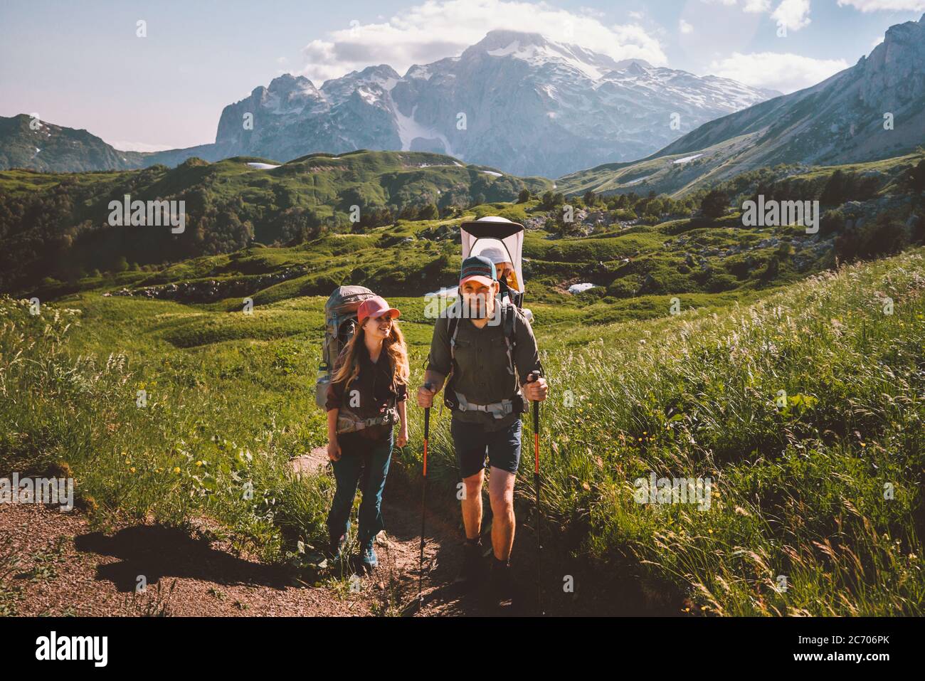 Paar Wanderreisen mit Baby im Rucksack Familienurlaub in den Bergen Mann und Frau im Freien gesunde Lebensweise Öko-Tourismus Sommerreise Stockfoto