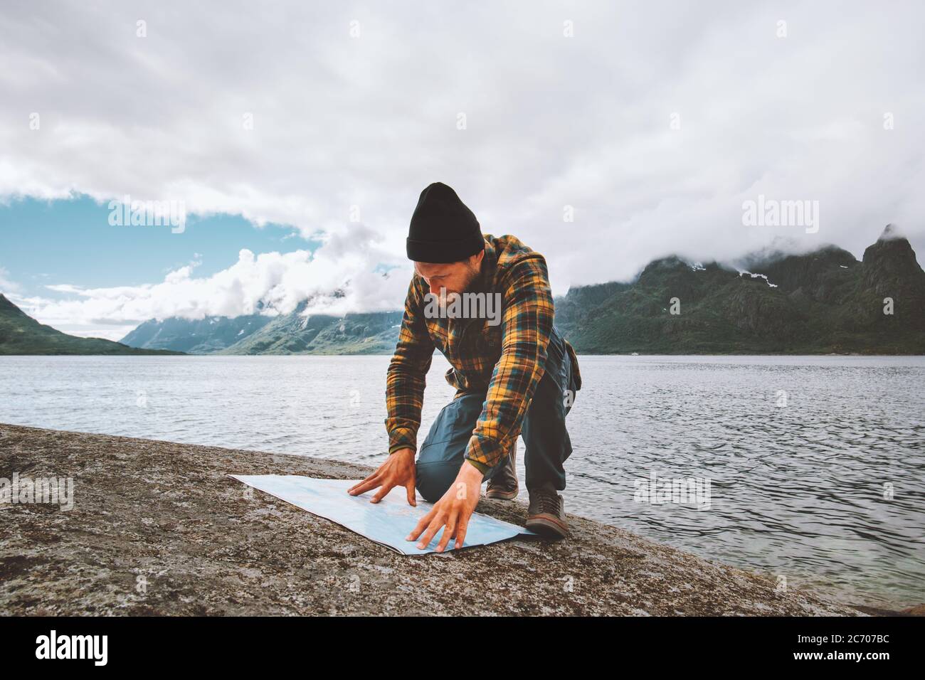 Mann schaut auf Karte Planung Urlaub Route Reise allein in Norwegen aktiv Abenteuer Lifestyle Wildnis Überleben Meer Fjord und nebligen Bergen Stockfoto