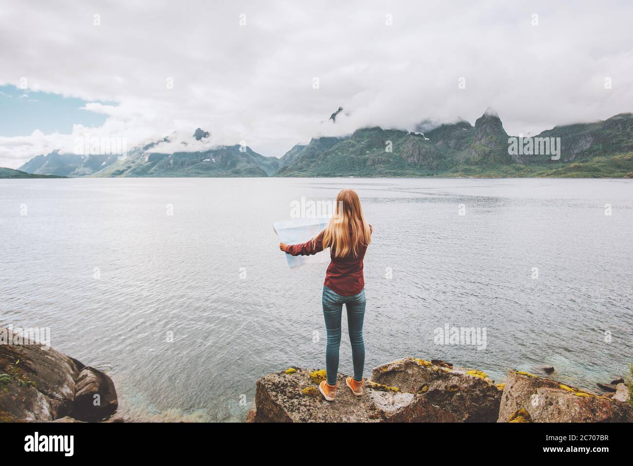 Frau auf der Karte Planung Urlaub Reisen allein in Norwegen aktiv Abenteuer Lifestyle Meer Fjord und nebligen Bergen Landschaft Stockfoto