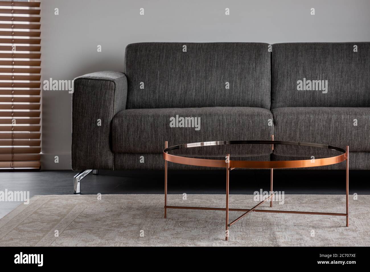 Stilvolle Innenausstattung mit grauer Couch und rundem Couchtisch Stockfoto