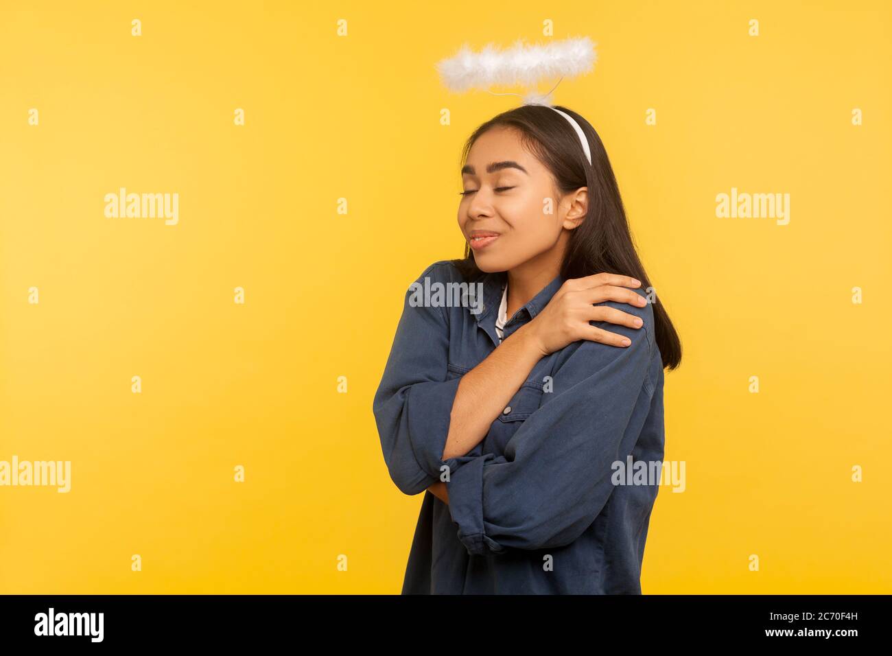 Ich bin der Beste! Portrait von engelhaften Mädchen mit Nimbus über Kopf umarmt und unterstützt sich, geschlossenen Augen mit Vergnügen, egoistisch, na Stockfoto