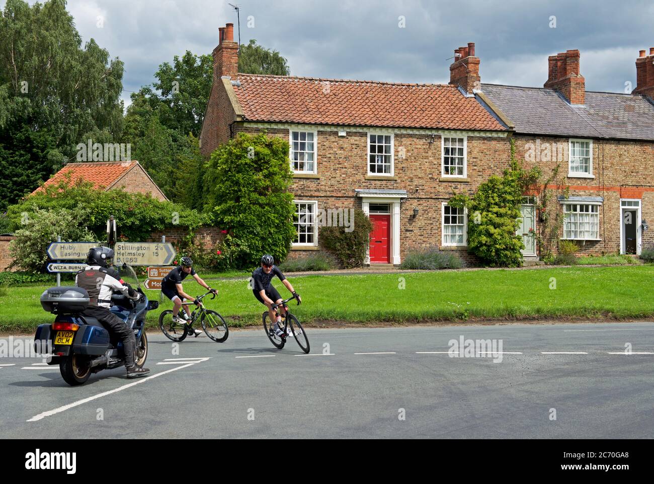 Radfahrer im Dorf Sutton on the Forest, Hambleton, North Yorkshire, England Stockfoto