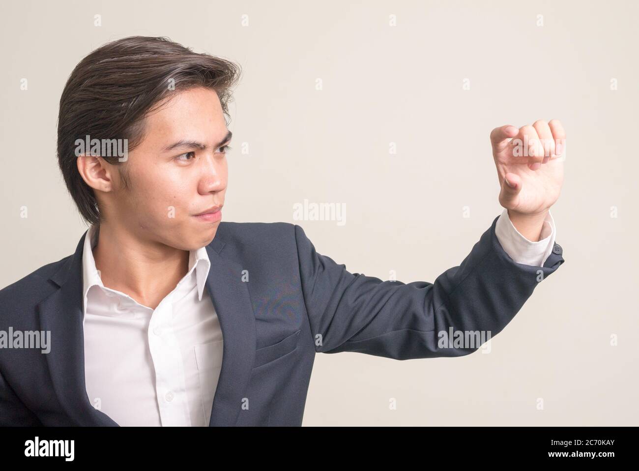 Gesicht des jungen philippinischen Geschäftsmann in Anzug Fokussierung mit Fingern Stockfoto