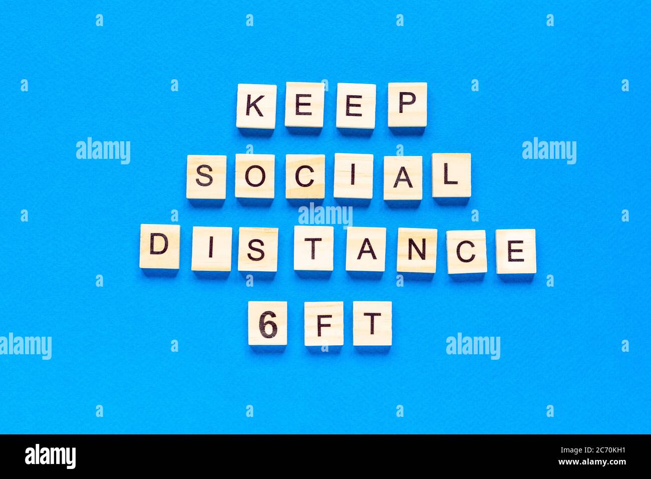 Wörter halten soziale Distanz 6 Fuß Holzbeschriftung auf blauem Hintergrund. Information Zeichen der sozialen Abstand 6 ft von Blöcken. Draufsicht Stockfoto