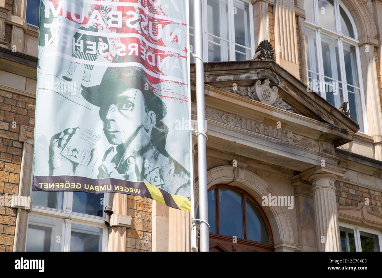 13. Juli 2020, Niedersachsen, Osnabrück: Eine Fahne mit dem Bild des jüdischen Künstlers Felix Nussbaum winkt vor der Villa Schlikker, in der sich das Kulturhistorische Museum der Stadt befindet. Die Stadt Osnabrück präsentiert erste Ideen für ein neues NS-Denkmal im Museumsquartier. In der "Villa Schlikker", dem ehemaligen NSDAP-Hauptquartier, will die Stadt dem Werk des NS-Funktionärs Hans Calmeyer kritisch Tribut zollen. Foto: Friso Gentsch/dpa Stockfoto