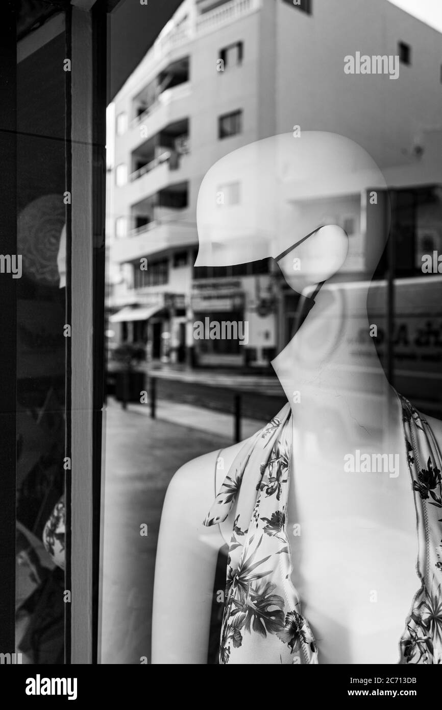Shop Dummy trägt eine Gesichtsmask und Reflexionen auf der Avenida de Suecia, während der Nachwirkung der covid 19 Lockdown, Los Cristianos, Teneriffa, Kanarische Inseln Stockfoto