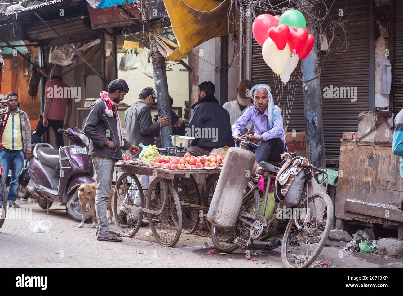 Neu Delhi / Indien - 18. Februar 2020: Alter Inder verkauft Früchte und bunte Ballone im Straßenstand in Alt-Delhi Stockfoto