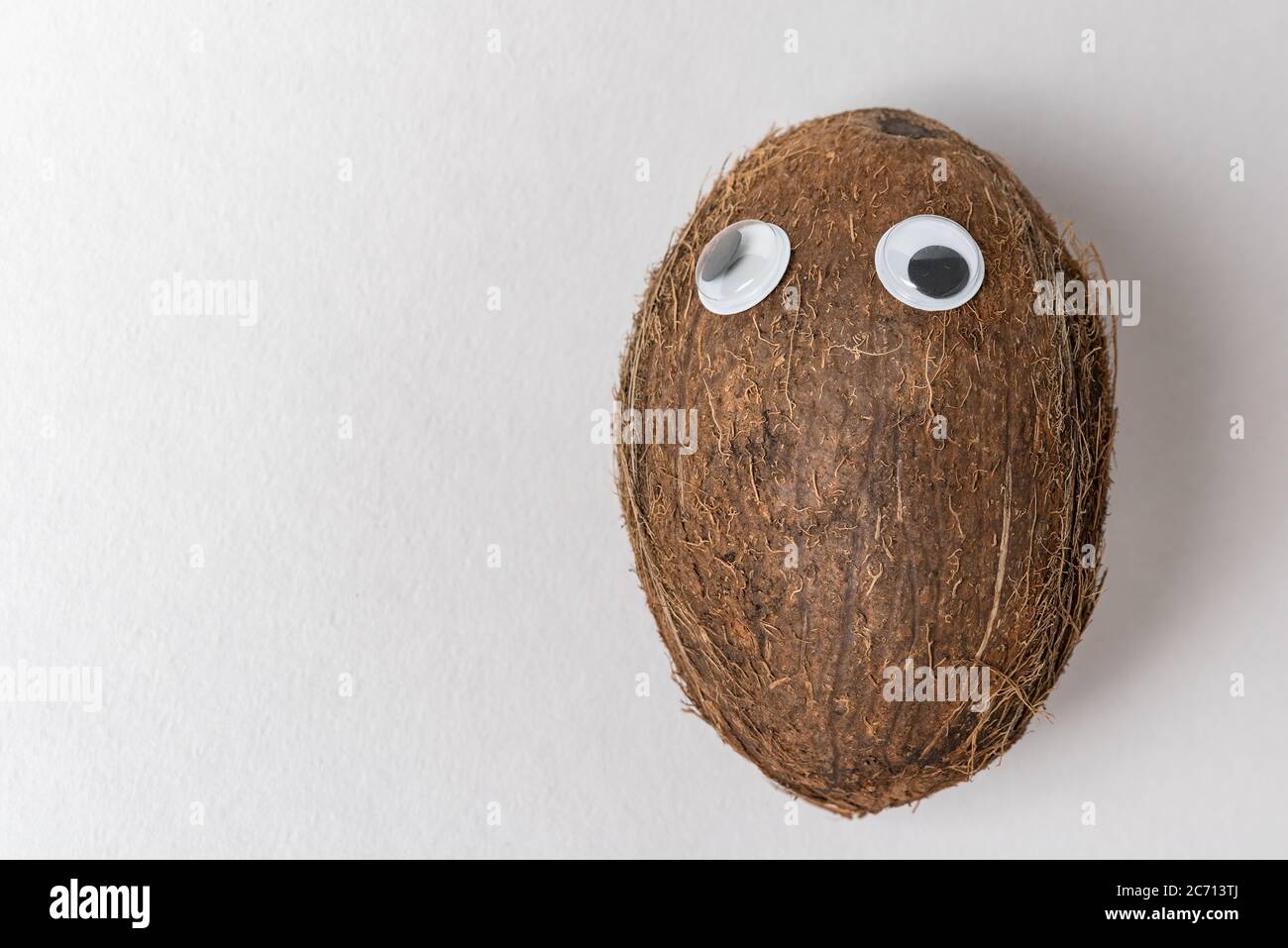 Kokosnuss mit Schwanenaugen und witzigem Gesicht. Verrücktes Nut-Konzept. Stockfoto