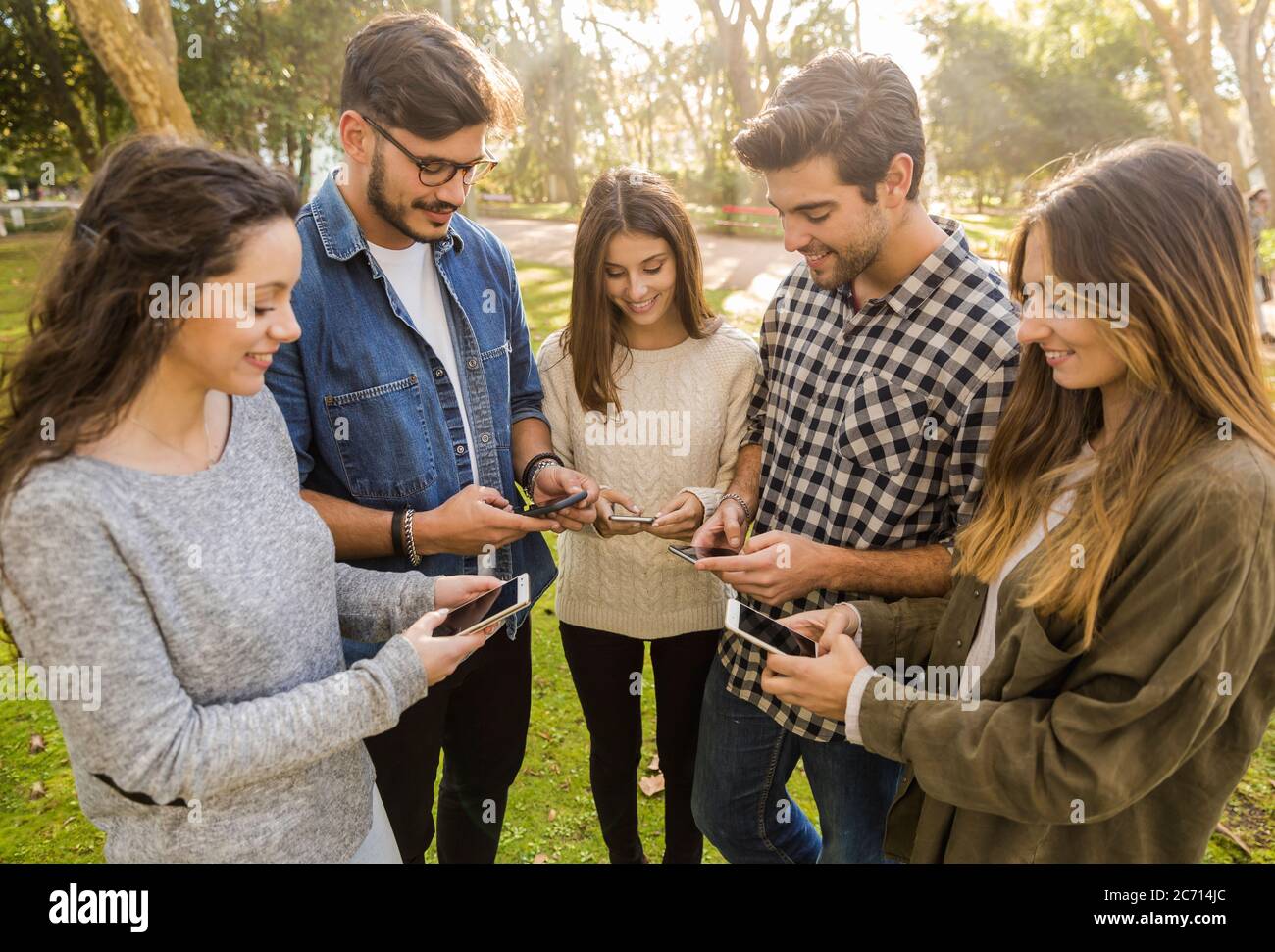 Eine Gruppe von Freunden im Park rumhängen in sozialen Netzwerken Stockfoto