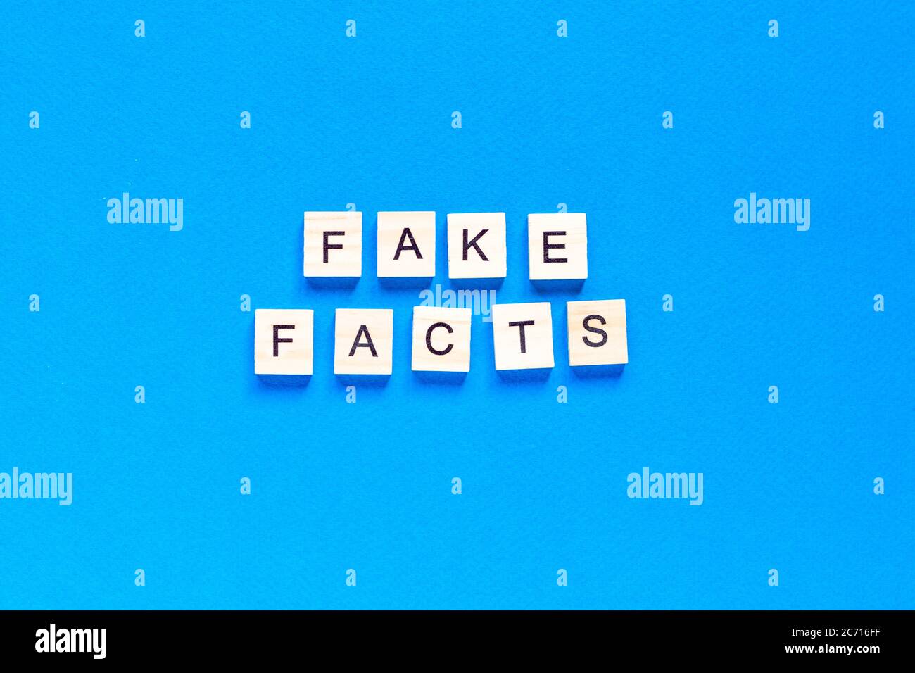 Fake Facts Wort Buchstaben auf blauem Hintergrund. Flaches Layout. Draufsicht. Stockfoto