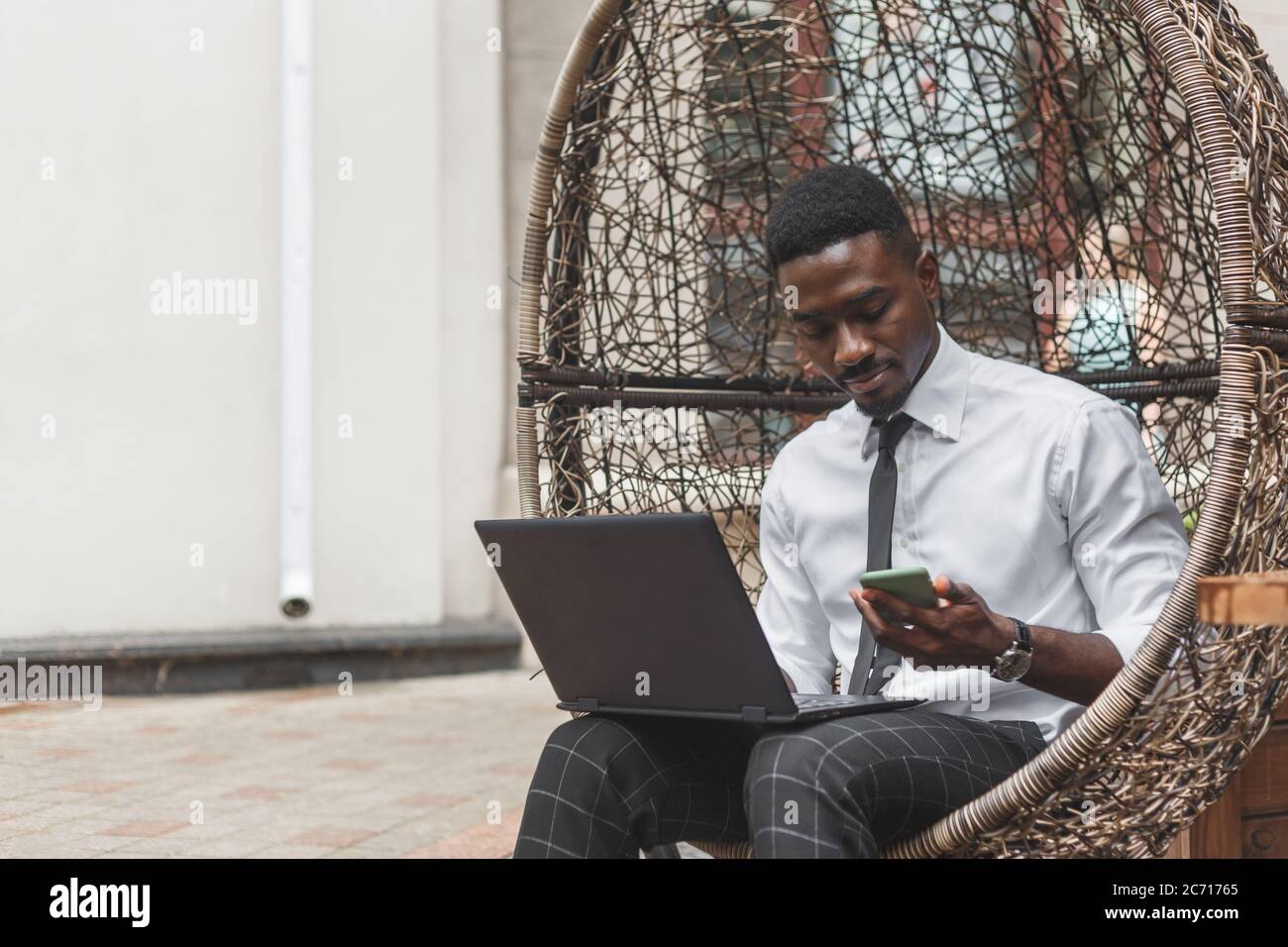 Afrikanischer Geschäftsmann sieht einen eingehenden Anruf im Telefon. Stockfoto
