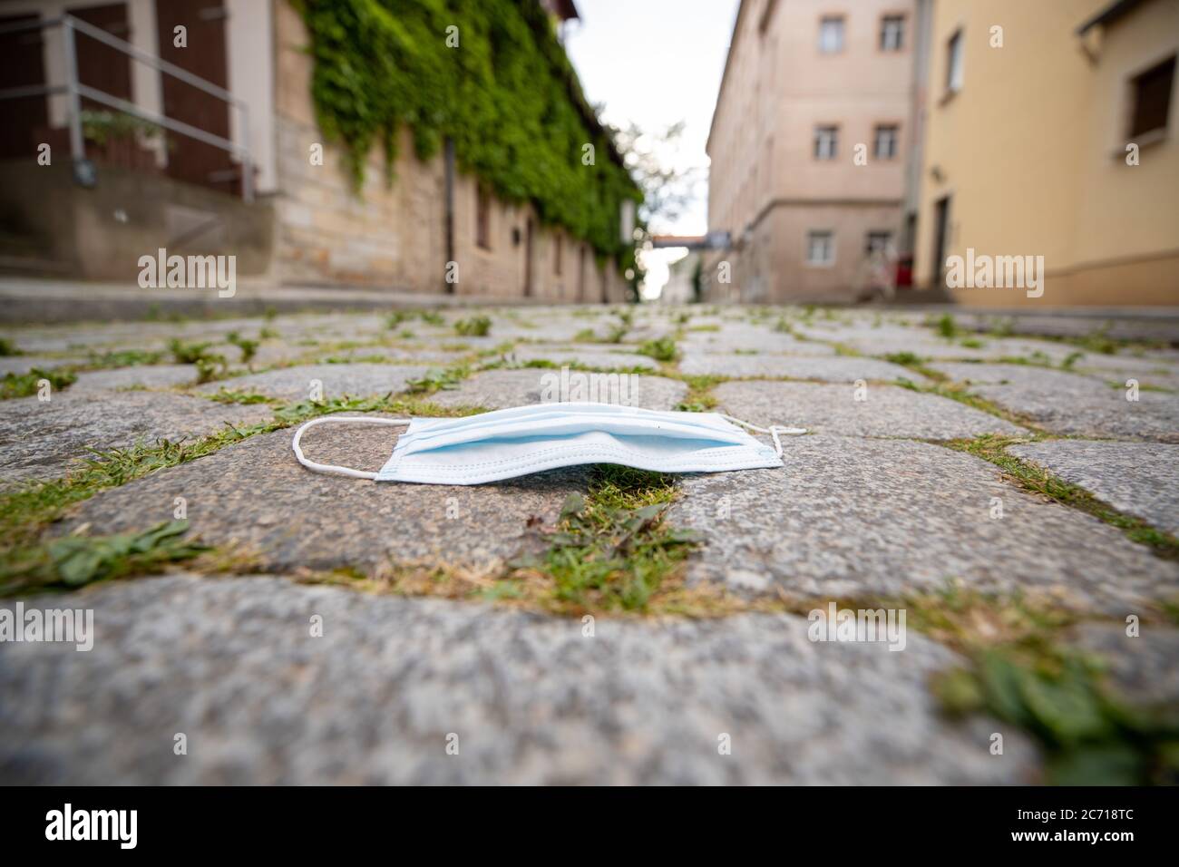 Pirna, Deutschland. Juli 2020. Auf dem Bürgersteig der historischen Altstadt der sächsischen Stadt Pirna wird eine Kopfsteinpflastermaske über Mund und Nase platziert. Für manche Menschen ist das Tragen der Maske einfach ärgerlich und doch gibt es einen Teil der Gesellschaft, der sie zum Selbstschutz gegen Infektionen trägt. Quelle: Daniel Schäfer/dpa-Zentralbild/ZB/dpa/Alamy Live News Stockfoto