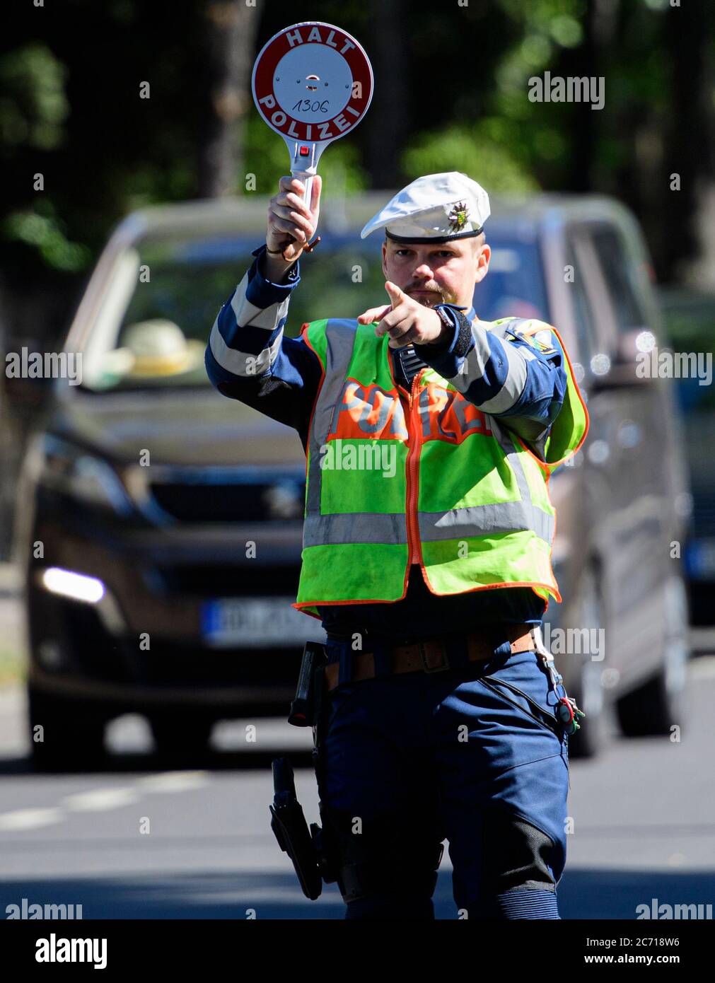 Dresden, Deutschland. Juli 2020. Ein Motorradpolizist winkt bei einer Polizeikontrolle, die prüft, ob bei der Überholung von Radfahrern der Mindestabstand von 1.5 Metern eingehalten wird, einen Polizeikelle zur Seite eines Autofahrers. Mit diesem Sicherheitsprojekt wollen die Polizeidirektion Dresden und der ADFC Sachsen auf die Novellierung der Straßenverkehrsordnung aufmerksam machen, in der spezifische Entfernungsregelungen für Überholungen eingeführt wurden, und die Verkehrsteilnehmer entsprechend sensibilisieren. Quelle: Robert Michael/dpa-Zentralbild/dpa/Alamy Live News Stockfoto