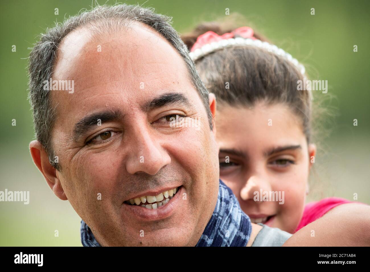 Glücklicher Vater mit Tochter umarmt im Freien. Stockfoto