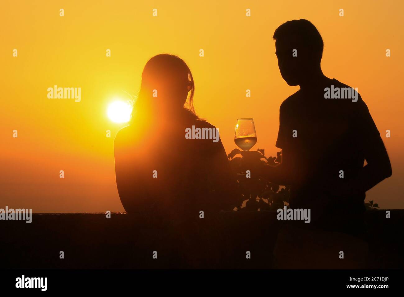 Romantisches Paar beobachten den Sonnenuntergang und feiern während des Urlaubs. Stockfoto