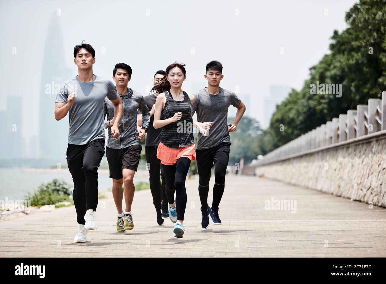 Gruppe von fünf jungen asiatischen erwachsenen Männern und Frauen laufen Training im Freien Stockfoto