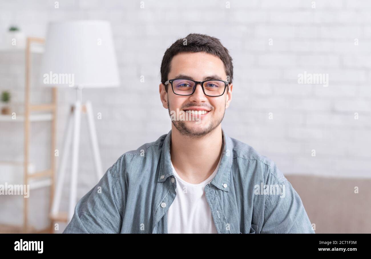Junger Geschäftsmann, der zu Hause arbeitet. Typ mit Brille im Innenraum Stockfoto