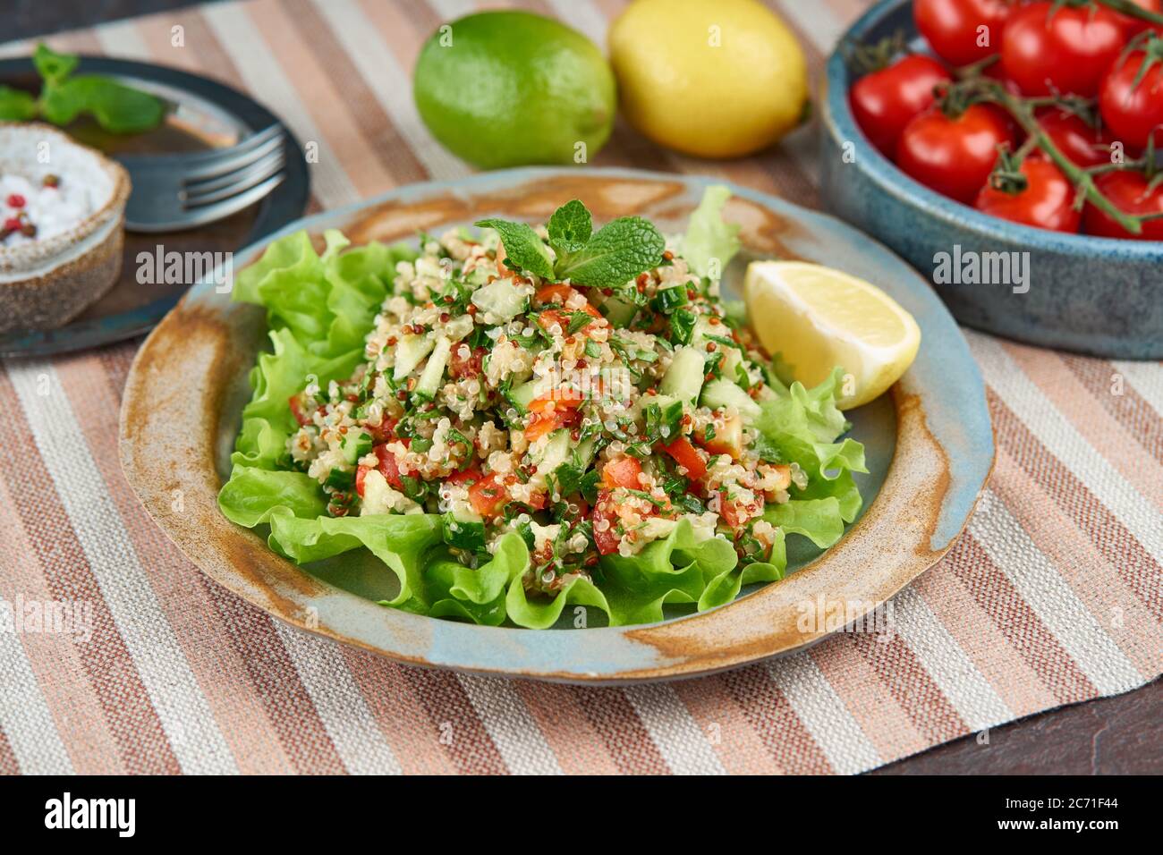 Tabboulehsalat mit Quinoa. Östliche Küche mit Gemüsemischung, vegane Ernährung. Seitenansicht, alte Platte Stockfoto